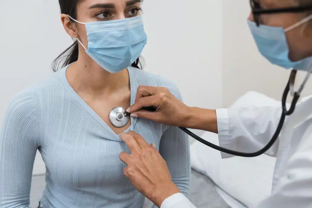 woman checking patient with stethoscope
